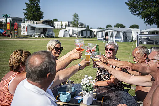 Vrienden proosten vrolijk op kampeerplaats bij camping CAPFUN Groene Eiland in Appeltern. Vrienden proosten vrolijk op kampeerplaats bij camping CAPFUN Groene Eiland in Appeltern.