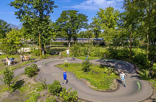 Pumptrack voor kinderen met scooters en fietsen op camping CAPFUN Wondermolen Molenschot.