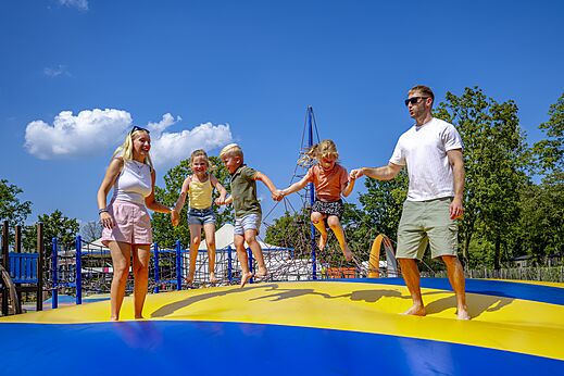 Familie plezier makend op het grote springkussen op camping CAPFUN de Wondermolen in Molenschot.
