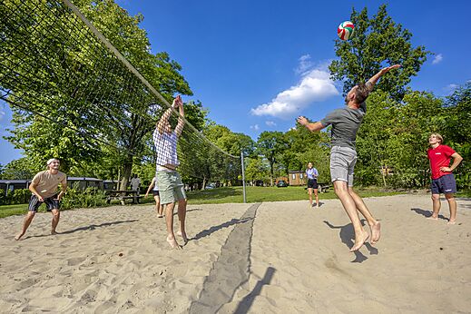 Zandstrandvolleybalveld met spelers op camping CAPFUN Wondermolen in Molenschot.